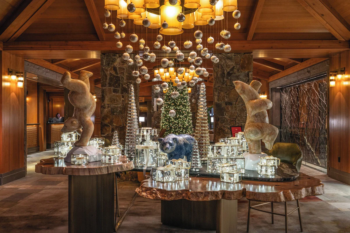 Four Seasons Resort and Residences Whistler lobby at Christmas, decorated with sparkling lights, festive garlands, and a glowing Christmas tree, creating a warm alpine holiday atmosphere.