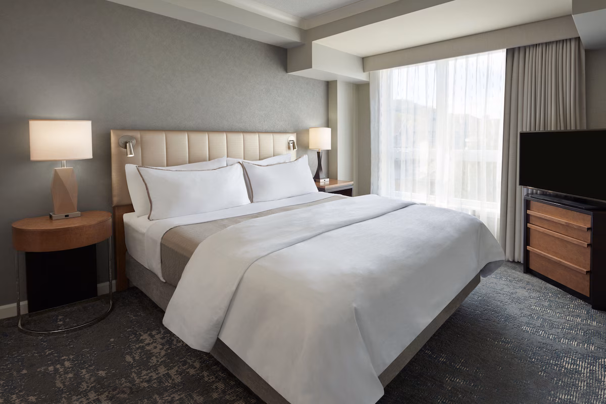 Guest room at The Westin Trillium House, Blue Mountain, featuring the signature Heavenly® Bed, modern lodge‑inspired décor, fireplace, and large windows with mountain or village views.