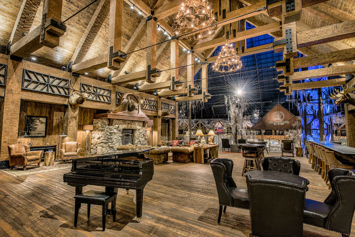 Lobby of Big Cypress Lodge in Memphis, Tennessee, featuring towering cypress trees, rustic wood beams, stone accents, and cozy seating areas that create the feel of a wilderness lodge inside the glass Pyramid.