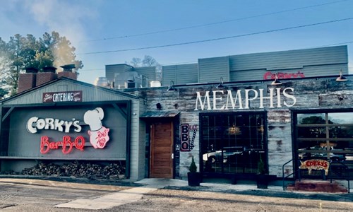 Exterior of Corky’s Ribs & BBQ in Memphis, Tennessee, featuring neon signage, rustic brick façade, and a welcoming entrance to one of the city’s most beloved barbecue restaurants.
