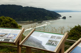 An informational plaque introducing visitors to the Klamath River Outlook with the outlook view in the background