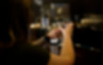Two people toasting with martini glasses at the Abalone Bar and Grill in a dimly lit setting, with the focus on their hands and the glasses.