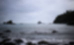 The coast of Trinidad on a stormy day with boats in the water.