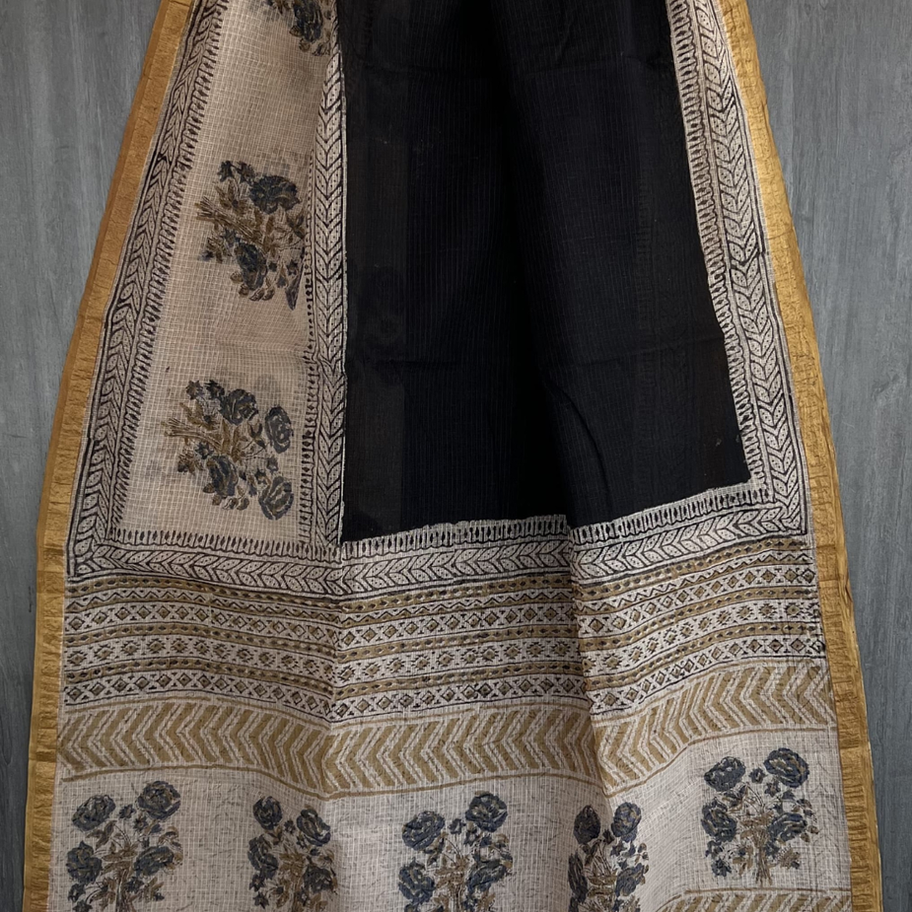 Black and mustard Kota Doria saree with floral patterns.