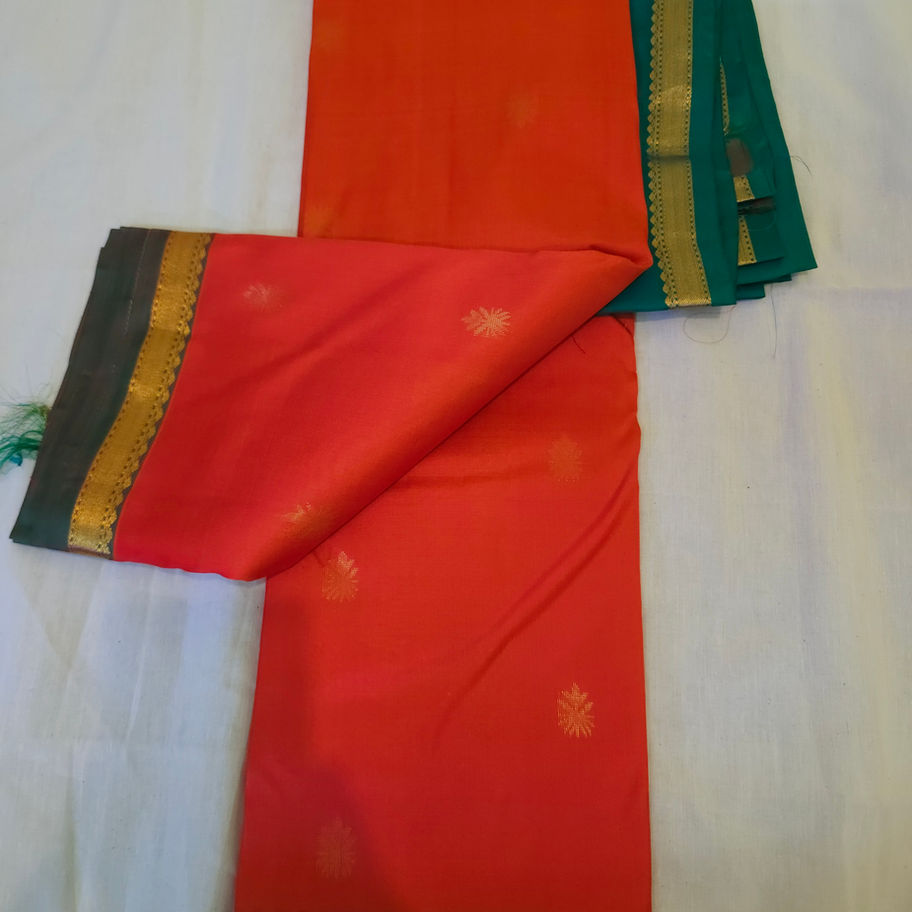Folded orange saree with small green and gold border