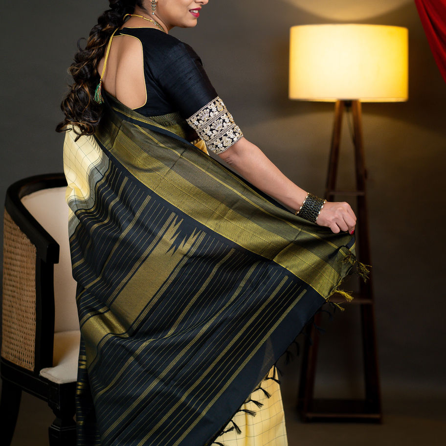 Woman draped in A20- Cream and Black Saree