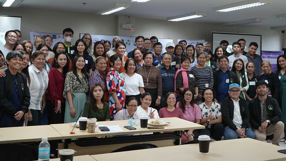 A group photo of the RURBANISE project consortium members, including researchers, community organizers, and partners from the University of Sheffield, UP Resilience Institute, TAMPEI, and HPFPI. The diverse group of men and women are smiling together in a brightly lit conference room in the Philippines, representing a collaborative workshop for urban climate resilience.