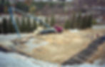 Concrete pump truck pouring foundations at a construction site.