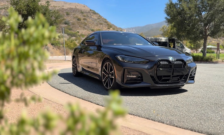 Eye-level view of a sleek red sports car parked on a scenic road