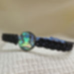 Close-up of black and blue silk bracelet with mother of pearl bead