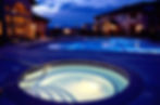 Night view of resort-style pool and hot tub