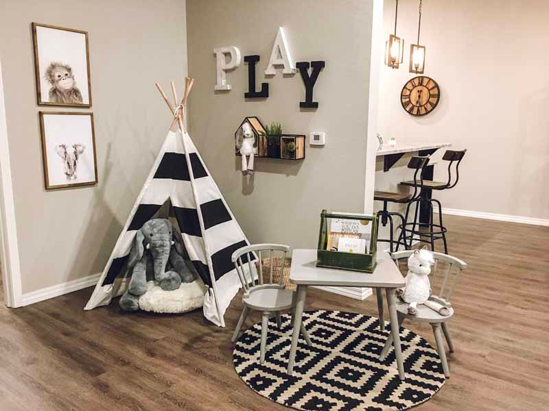 Playroom featuring teepee, animal decor, table, chairs, with the word PLAY