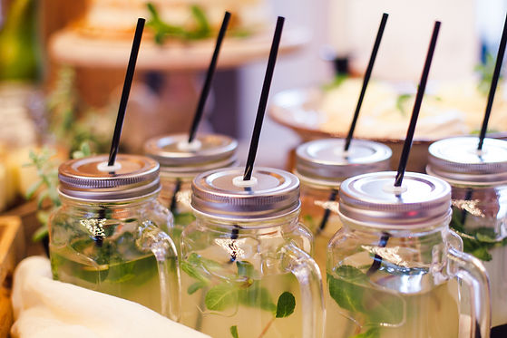 Lemonade with mint in glass cup with straws in area of wedding party.jpg