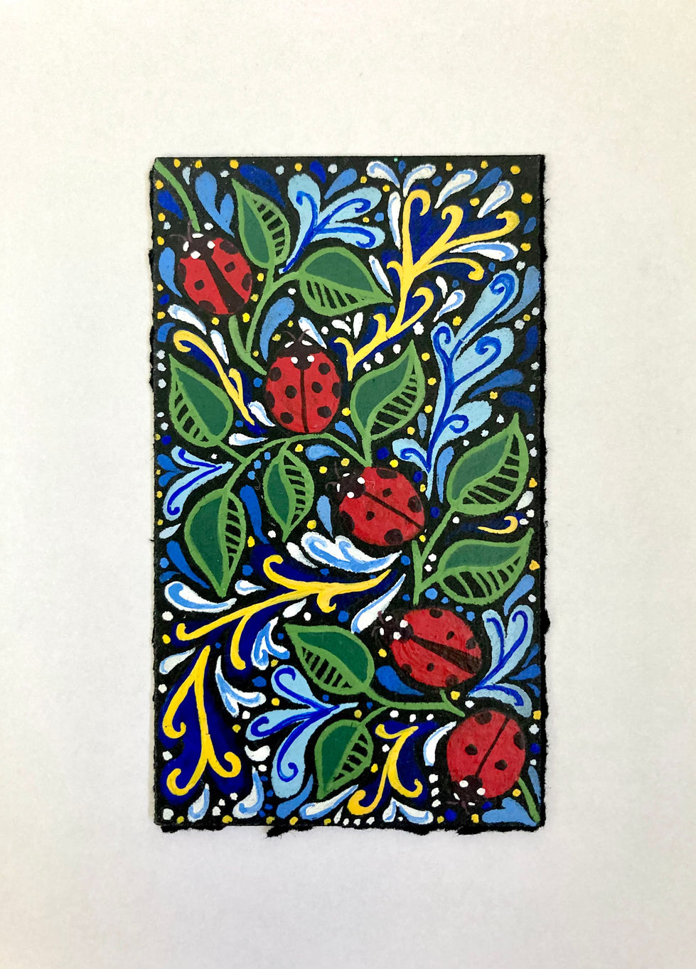 Gouache painting on a black background of five ladybugs lined up from bottom right to top left. The ladybugs are surrounded by green leaves and blue, white, and yellow flourishes