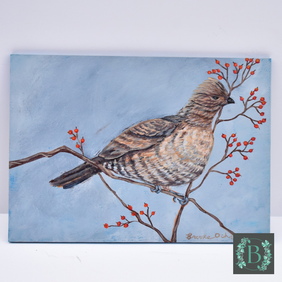 Brown and white bird on thin brown branches with orange berries on a gray blue background