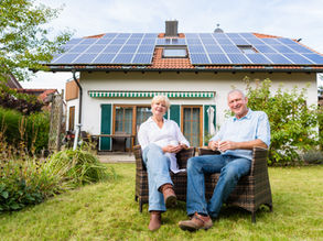 Homeowners sitting in front of home with solar panels