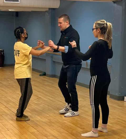 An instructor provides tips as two people dance bachata.