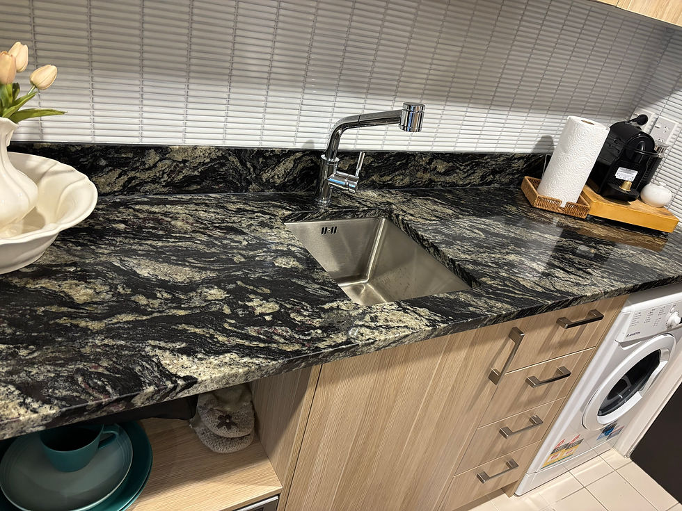 Luxury kitchen renovation with dramatic black marble benchtop, undermount sink, premium tapware, and custom timber cabinetry - complete kitchen design and installation services