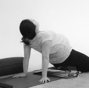 pregnant woman doing prenatal yoga for benefits in pregnancy, birth, and postpartum