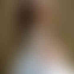 A girl in a flower girl dress holding flowers looking over her right shoulder