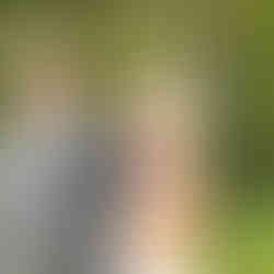 A bride excitedly waves towards the camera in the gardens of Brig o' Doon House Hotel