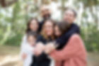 Upclose of family. Mom in the middle with Dad behind her and four children hugging them