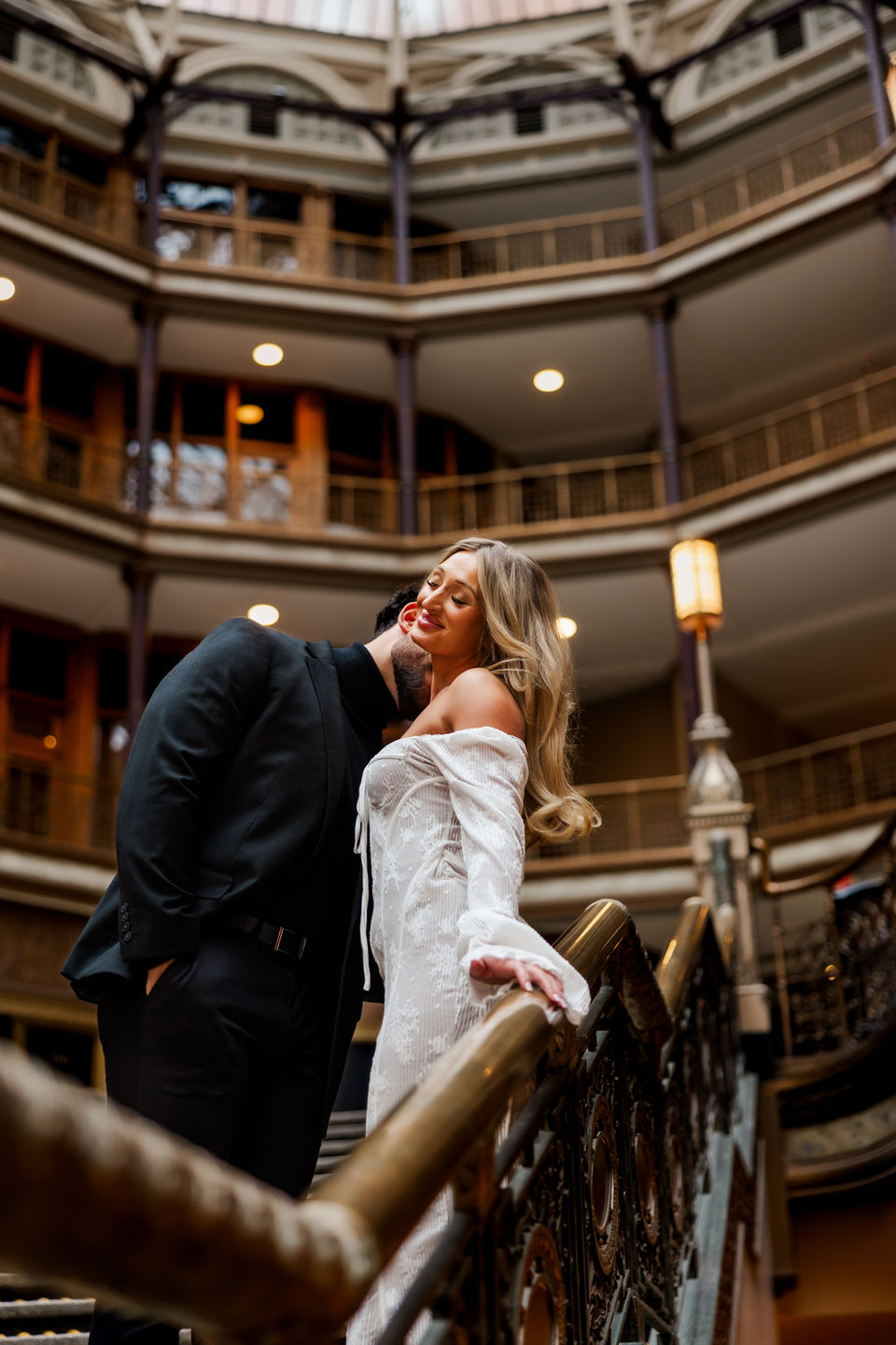 Bride and groom kiss on staircase in historic Cleveland wedding venue