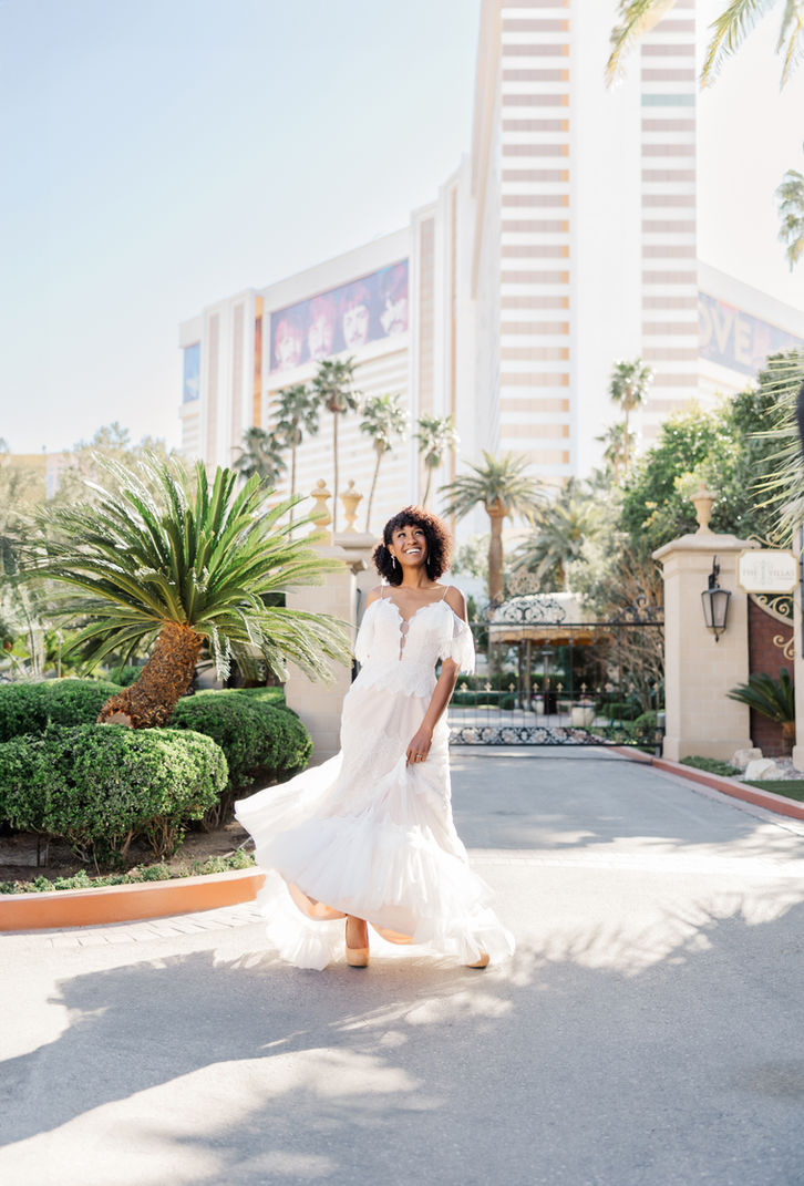 Bride in fitted gown on palm-lined terrace during destination wedding in Las Vegas