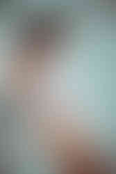 a brunette model leaning against the wall, posing in a pink bodysuit