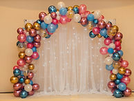multicolored balloon arrangement near white curtain