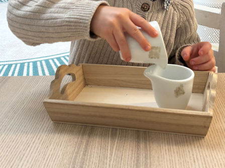 Boy at Treetops Montessori Pouring Water in the Practical Life Area
