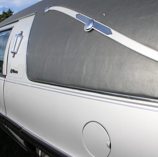 A silver 1990s Buick hearse with a badge reading SS Victoria.