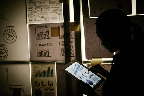 woman-standing-window-covered-with-business-charts-working-tablet.jpg