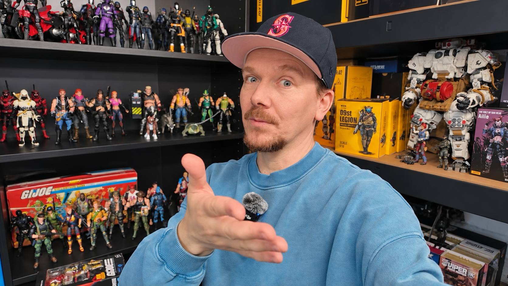 Marc in seiner Nerd Cave vor Regalen mit G.I. Joe und weiteren Actionfiguren