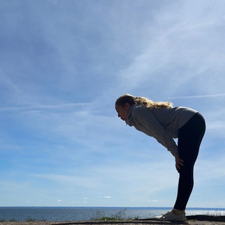 Katarina pustar ut i motljus vid sjön och himlen