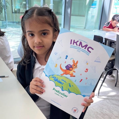 A school student holding IKMC International Kangaroo Competition booklet in UAE partipation