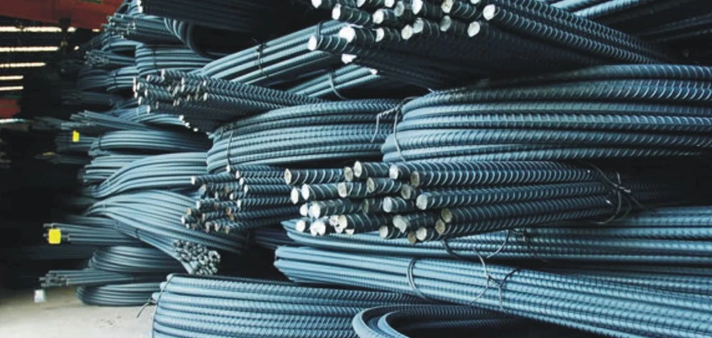 Bundles of ribbed TMT steel bars stacked in a warehouse ready for construction supply