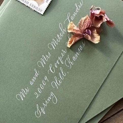 The prettiest green envelopes paired with white ink in a casual, flowy calligraphy script.