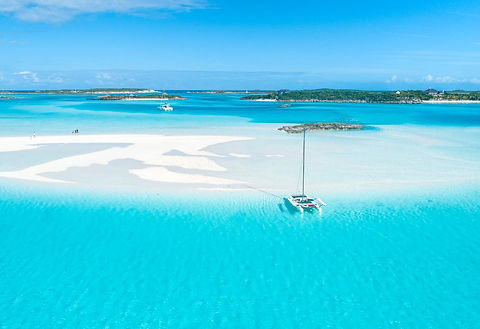 Luxury bareboat sailing yachts and catamarans anchored among the turquoise cays of the Exumas, The Bahamas.