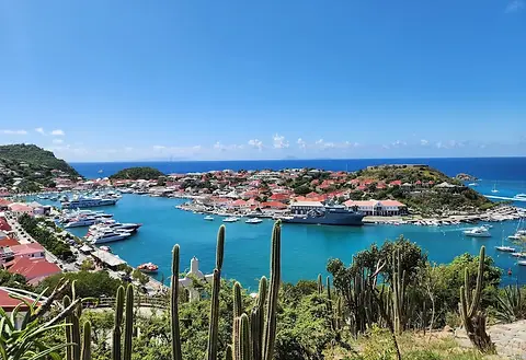 Luxury Bareboat Sailing Yachts and Catamarans anchored near a tropical beach in St. Barts.