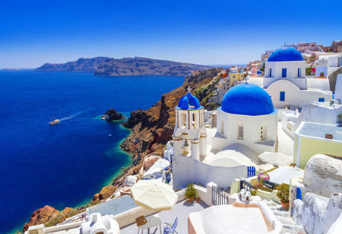 Bareboat Sailing yachts and catamarans cruising near the cliffs of Santorini, Greek Islands.