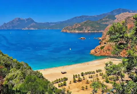 Luxury bareboat sailing yachts and catamarans navigating the spectacular waters of the Gulf of Porto along Corsica’s scenic coastline.