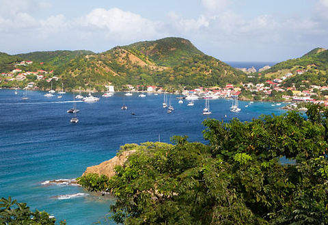 Luxury yachts, bareboat sailing yachts and catamarans anchored in a beautiful bay of Martinique.