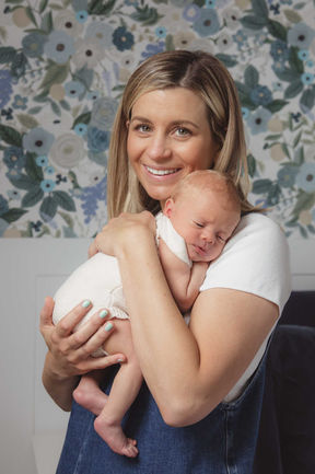 A mum holding her newborn baby during a newborn photoshoot at home in Essex.