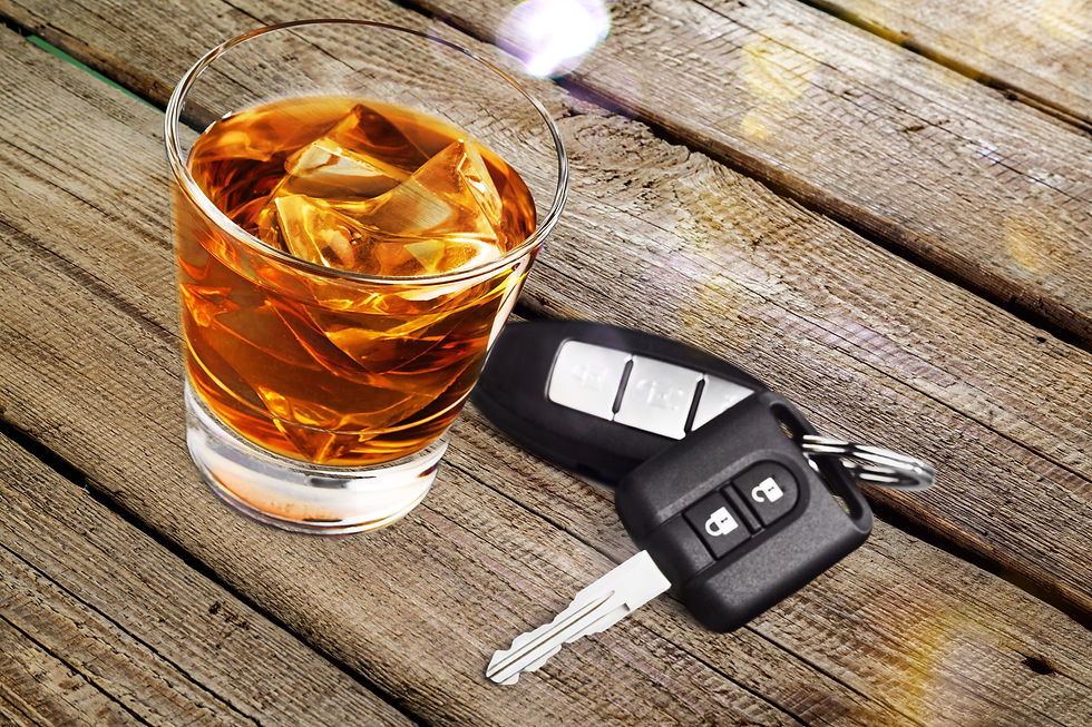 Mixed drink in a glass and car keys laying on a weathered wood.
