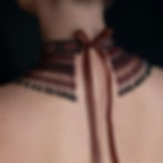 Back view of the elegant burgundy necklace, with a ribbon tied into a bow, adding a delicate and stylish finishing touch to the design.