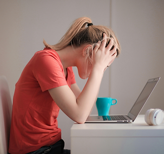 girl at computer with head in her hands