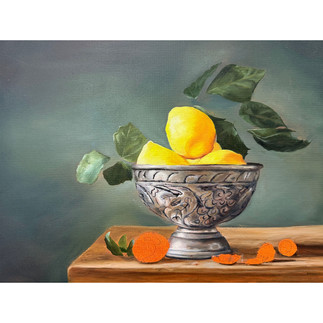 Still life oil painting of a silver ornate bowl holding bright yellow lemons with green leaves, set on a wooden surface with scattered walnut shells.