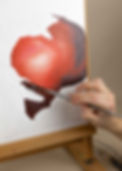 photograph of the process of painting including hand and brush