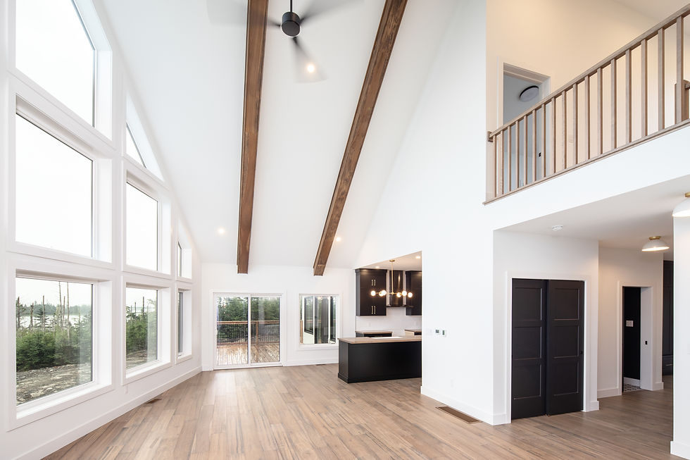 Spacious custom home interior featuring stunning large windows and a sleek, modern kitchen with dark cabinetry and elegant lighting.